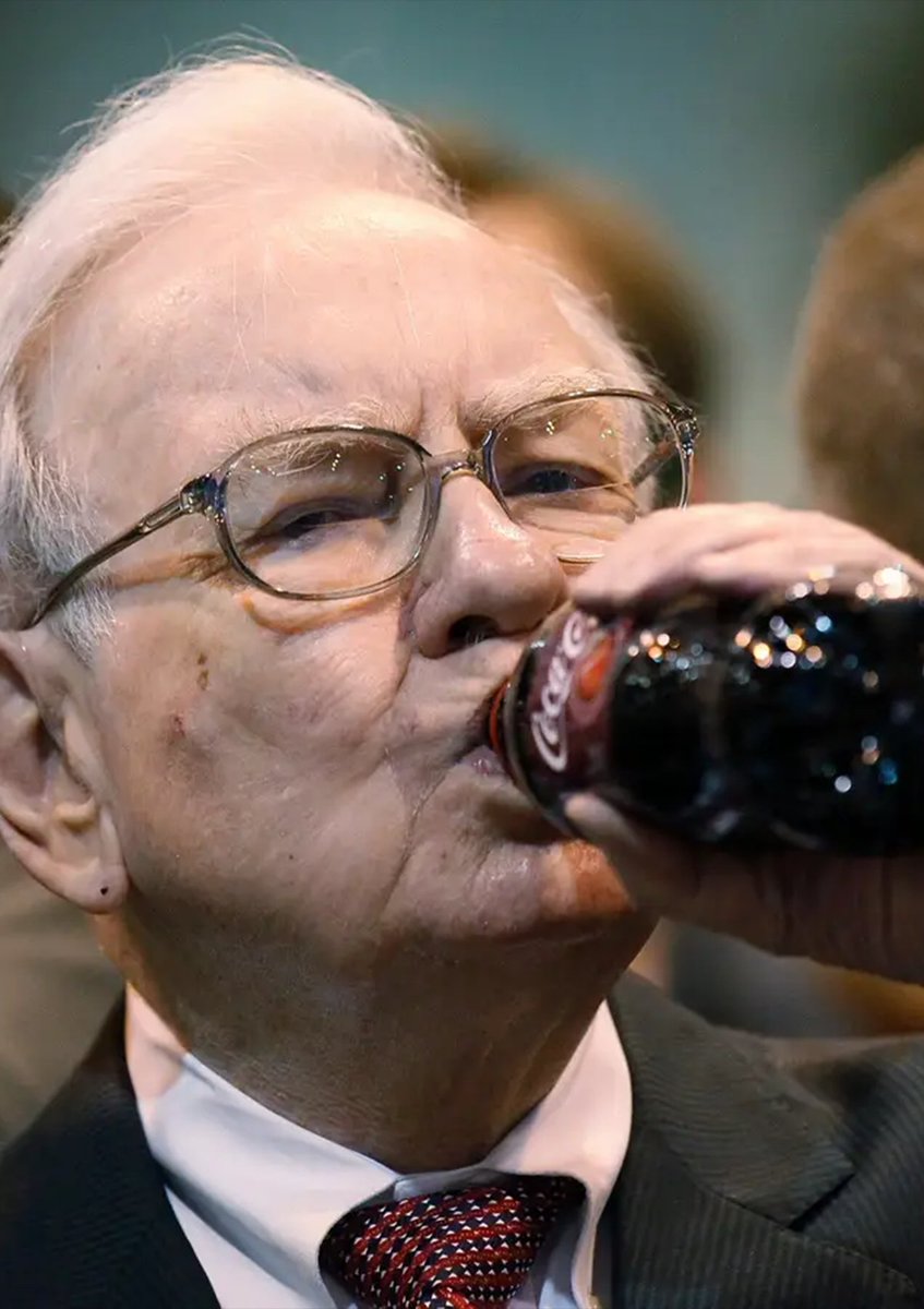Warren Buffett 手持一瓶可口可樂飲用